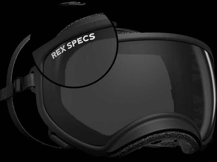 A close-up of black goggles with the "REX SPECS" logo, featuring a sleek design and adjustable straps.
